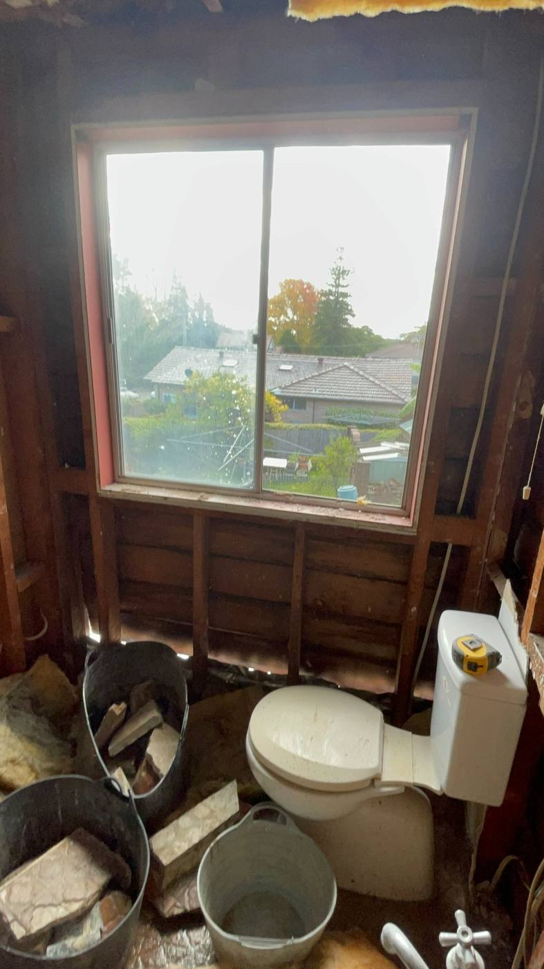 Bathroom stripped back to bare timber wall studs with the window opening exposed during renovation, Baulkham Hills by Loel Homes