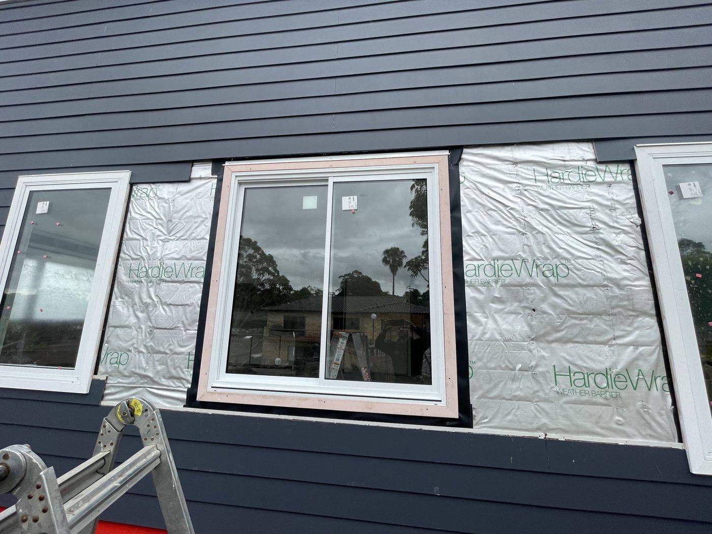 Window opening with HardieWrap patched around it ready for weatherboard reinstatement, navy cladding by Loel Homes