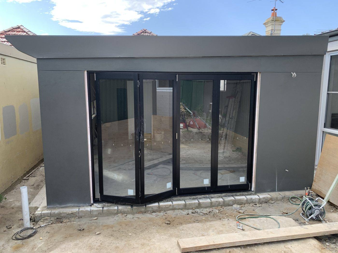 Completed charcoal-rendered rear extension with bi-fold doors, Dulwich Hill by Loel Homes