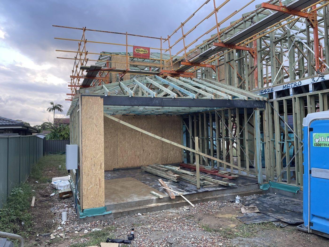 Wall frames going up on a two-storey new build with scaffold by Loel Homes