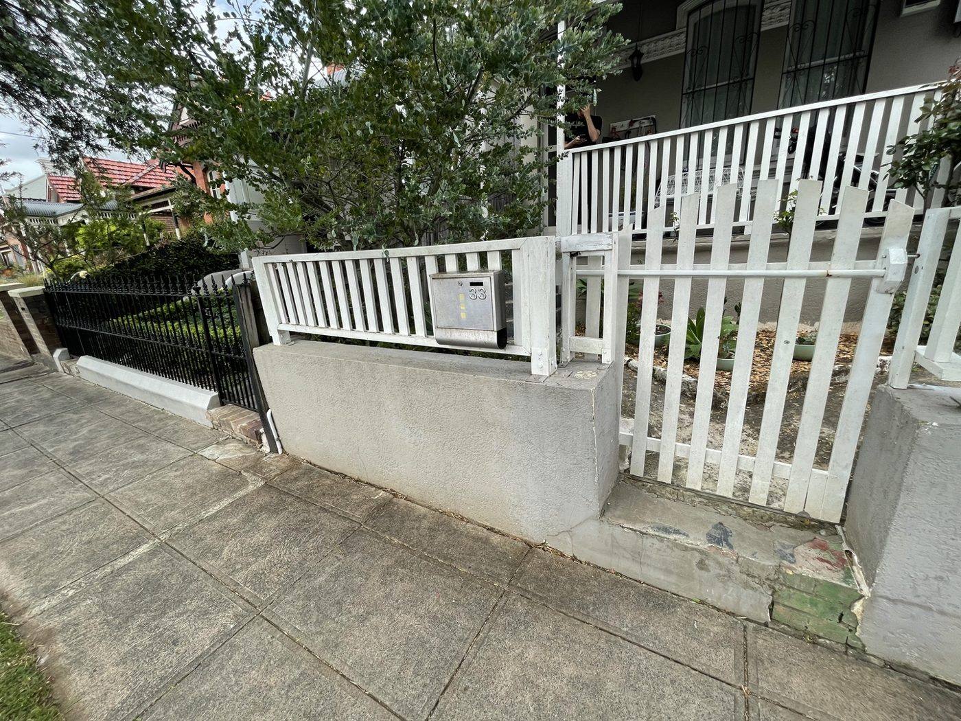 New white picket gate and rendered wall at the front of the finished terrace by Loel Homes