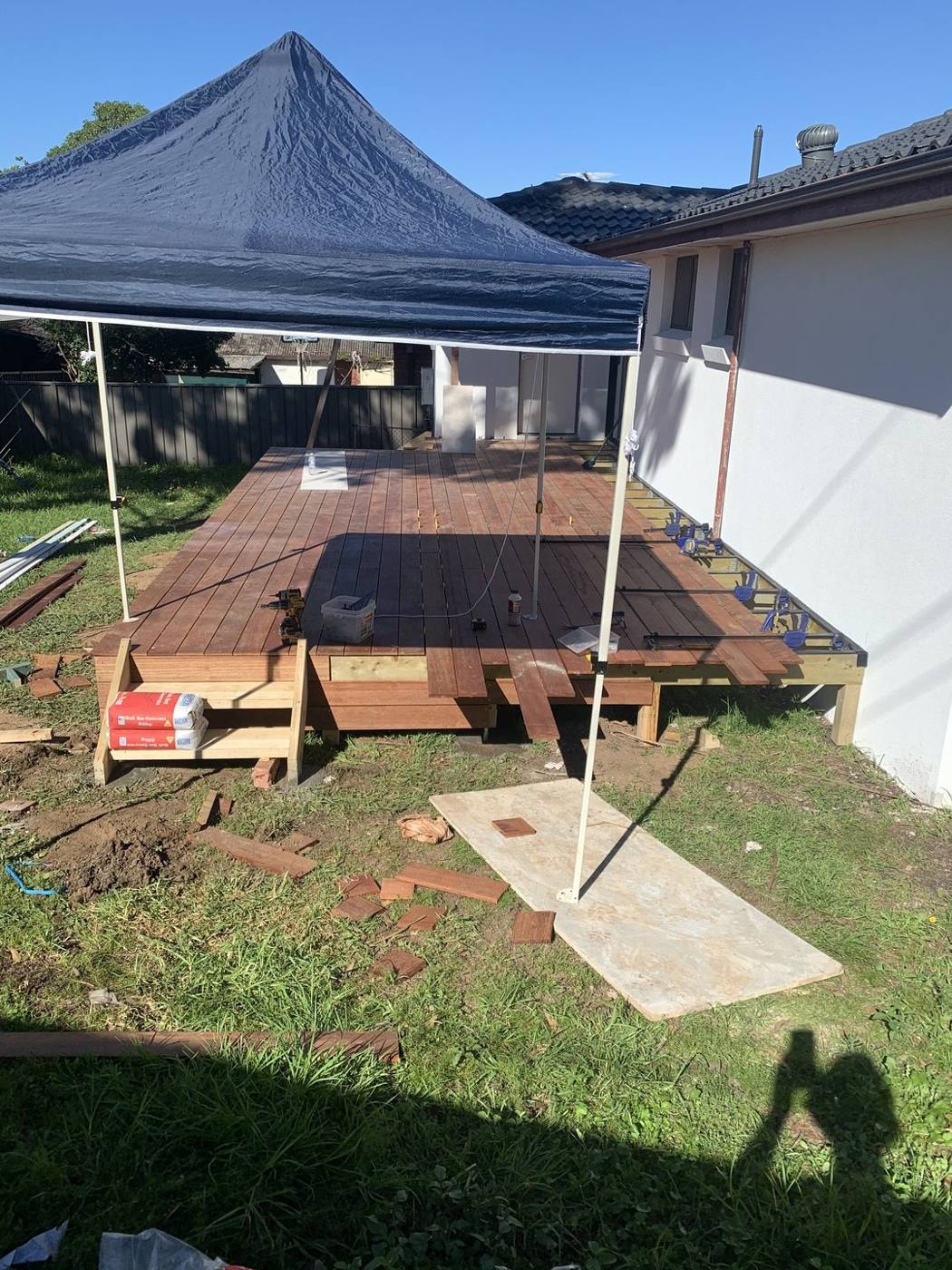Rear hardwood deck part-laid under a gazebo tent during the build by Loel Homes